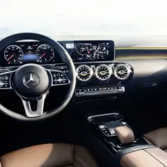 L'intérieur luxueux de la Mercedes Classe A, avec ses sièges en cuir brun, son volant moderne et son grand écran d'infodivertissement.