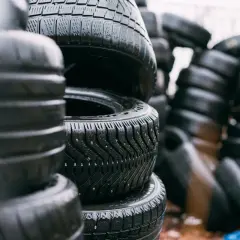 Piles de pneus usagés, certains avec des crampons. Le dessin de la bande de roulement permet de deviner le sens de rotation pneu sans flèche.