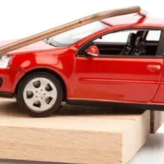 Une petite voiture rouge est piégée sur une souricière. Attention, voici comment acheter une voiture d'occasion sans tomber dans le piège !