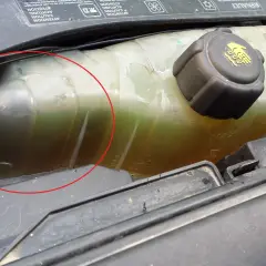 Réservoir de liquide de refroidissement d'une Clio 3, le niveau est bas. Le liquide est verdâtre et trouble.