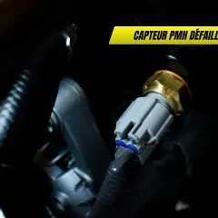 Gros plan sur un capteur PMH défaillant, essentiel au régime moteur. Sa connexion grise est visible.