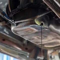 Goutte d'huile moteur s'écoulant du carter. Une fuite à réparer, le prix peut varier.