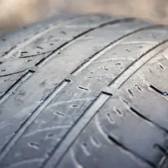 Gros plan sur un pneu usé, montrant les rainures aplaties. Difficile de dire combien de km avec des pneus dans cet état.