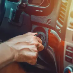 Main d'un conducteur tournant la clé de contact, espérant que la voiture cale en roulant ne se reproduise pas.