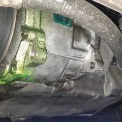 Recherche fuite clim auto : le compresseur est couvert d'un liquide vert fluorescent, signe d'une fuite.