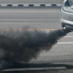 Nuage de fumée noire sortant du pot d'échappement d'une voiture sur la route. Ma voiture sent le chaud, c'est inquiétant.