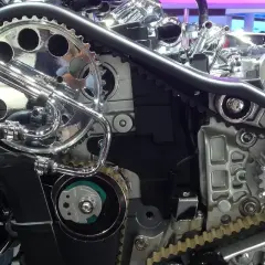 Mécanisme de moteur avec courroie crantée et galet tendeur. Un bruit suspect pourrait indiquer un problème.