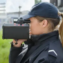 Agent de police utilisant un radar pour mesurer la vitesse. Même un excès de vitesse inférieur à 5 km/h peut être verbalisé.