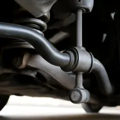 Suspension de voiture avec biellette de direction usée, potentiellement source de bruit.
