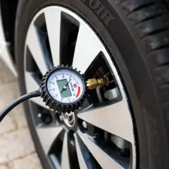 Manomètre mesurant la pression des pneus d'une Toyota Yaris. Le cadran affiche la mesure.