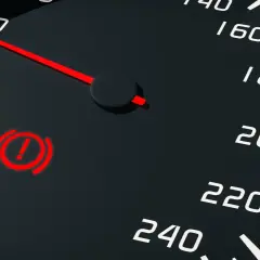 Voyant rouge de panne du système de freinage allumé sur le tableau de bord, à côté de l'indicateur de vitesse.