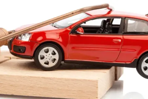 Une petite voiture rouge est piégée sur une souricière. Attention, voici comment acheter une voiture d'occasion sans tomber dans le piège !