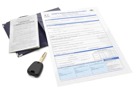Document de demande de carte grise utilitaire, avec une clé de voiture posée dessus.