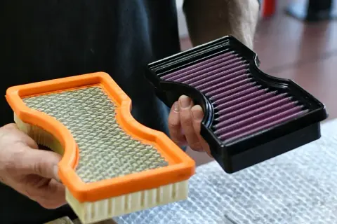Comparaison entre un filtre à air standard et un filtre à air haute performance violet.