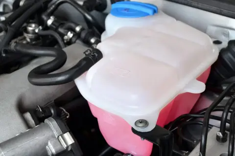 Réservoir de liquide de refroidissement rose vif, prêt pour le remplissage. Vérifiez le niveau avant de savoir ou mettre le liquide de refroidissement.