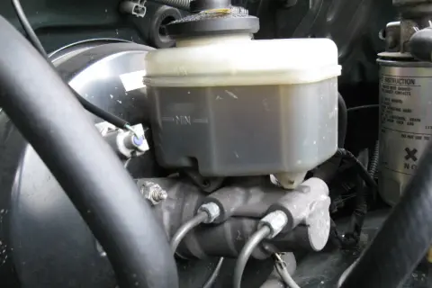 Le réservoir du maître cylindre de frein, avec ses indicateurs MAX et MIN, est visible dans le compartiment moteur.