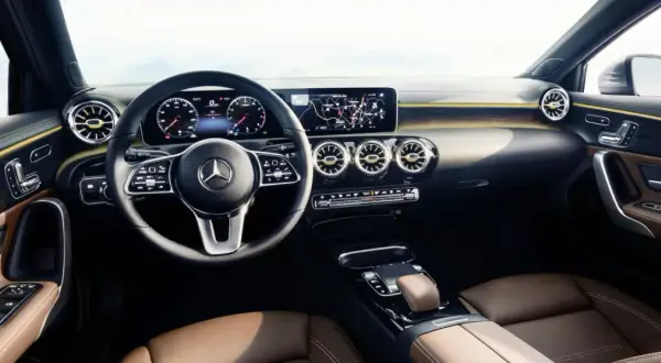 L'intérieur luxueux de la Mercedes Classe A, avec ses sièges en cuir brun, son volant moderne et son grand écran d'infodivertissement.