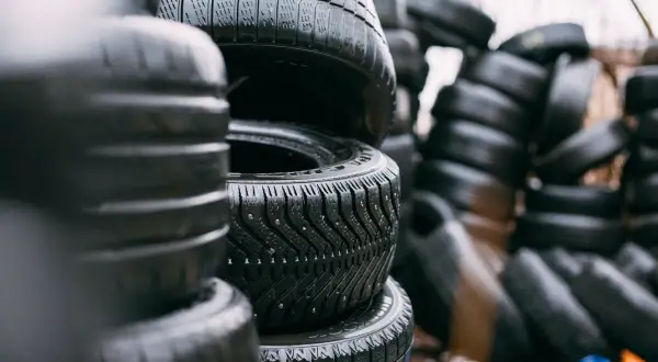 Piles de pneus usagés, certains avec des crampons. Le dessin de la bande de roulement permet de deviner le sens de rotation pneu sans flèche.