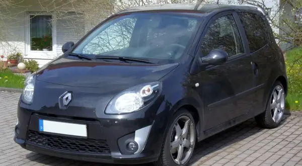 Renault Twingo 2 noire garée sur pavés. Les jantes alliage et le pneu sont visibles.