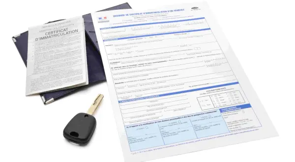 Document de demande de carte grise utilitaire, avec une clé de voiture posée dessus.