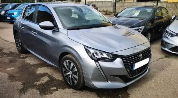 Peugeot 208 grise, prête pour sa révision. Le tarif de la révision Peugeot 208 est affiché sur le pare-brise.