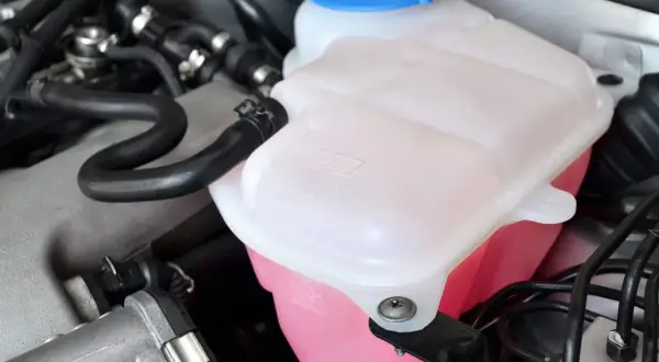 Réservoir de liquide de refroidissement rose vif, prêt pour le remplissage. Vérifiez le niveau avant de savoir ou mettre le liquide de refroidissement.