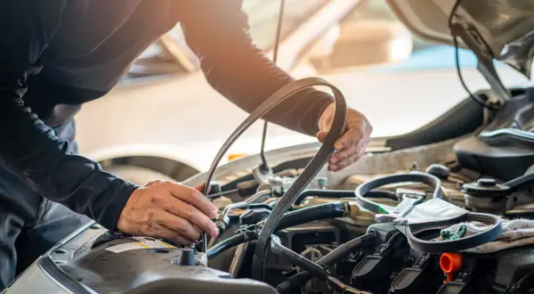 Mécanicien remplaçant la courroie de distribution d'une Twingo 2. L'entretien est essentiel pour le bon fonctionnement du moteur.