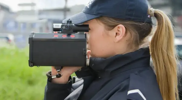 Agent de police utilisant un radar pour mesurer la vitesse. Même un excès de vitesse inférieur à 5 km/h peut être verbalisé.