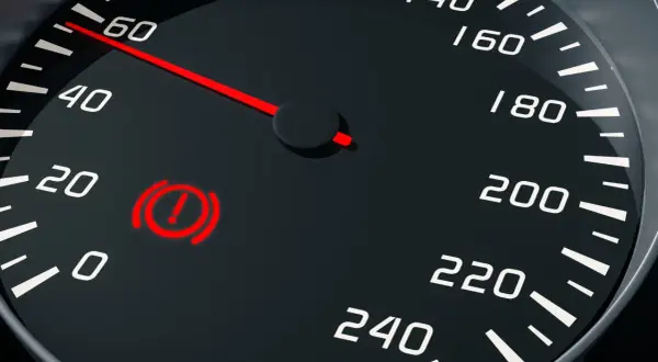 Voyant rouge de panne du système de freinage allumé sur le tableau de bord, à côté de l'indicateur de vitesse.
