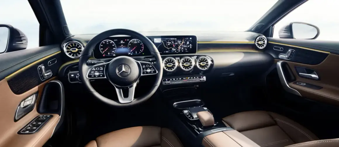 L'intérieur luxueux de la Mercedes Classe A, avec ses sièges en cuir brun, son volant moderne et son grand écran d'infodivertissement.