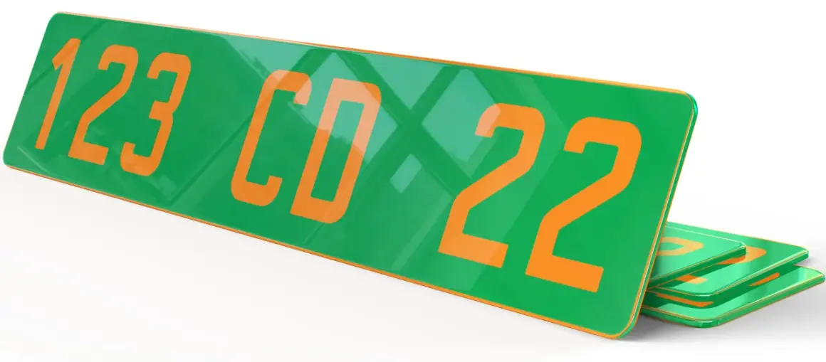 Plaque verte et orange avec les numéros "123 CD 22" en gros caractères. D'autres plaques similaires sont empilées en dessous.