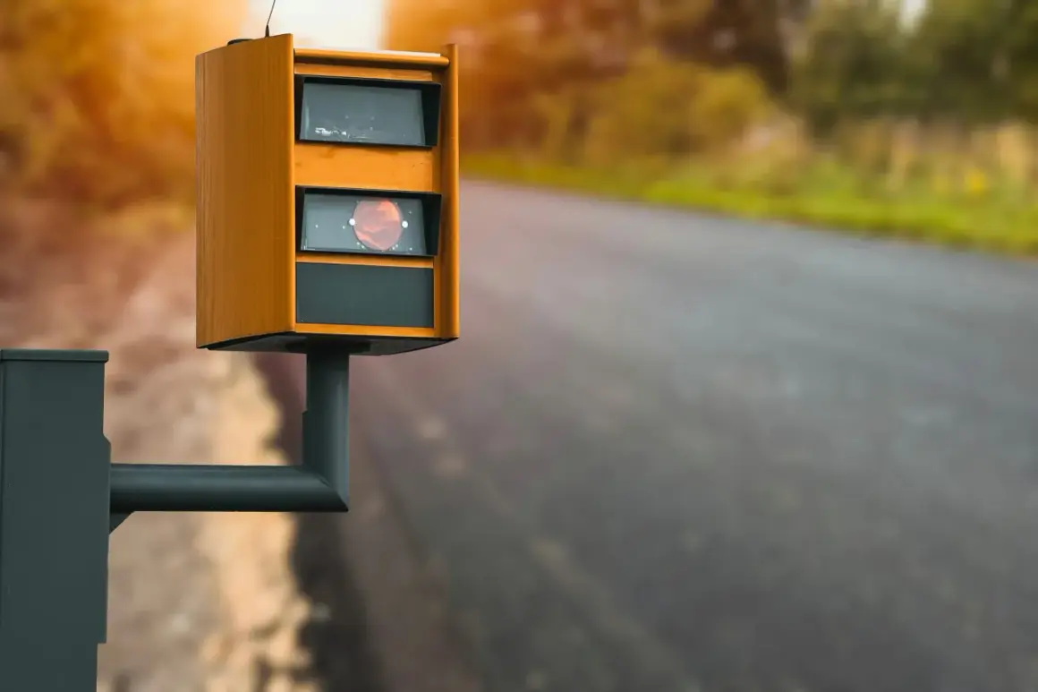 Radar de vitesse orange sur le bord de la route, rappelant de ne pas utiliser le téléphone au volant.