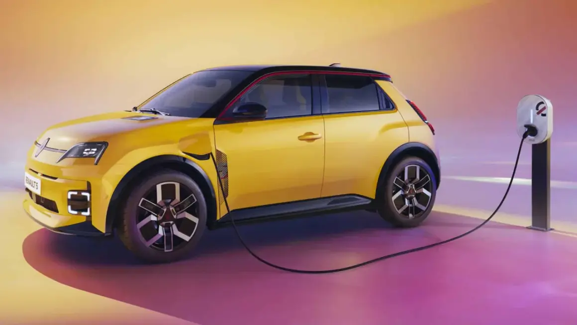 La Renault 5 électrique, jaune vif, se recharge. Une borne de recharge est connectée à la voiture, prête pour l'aventure.