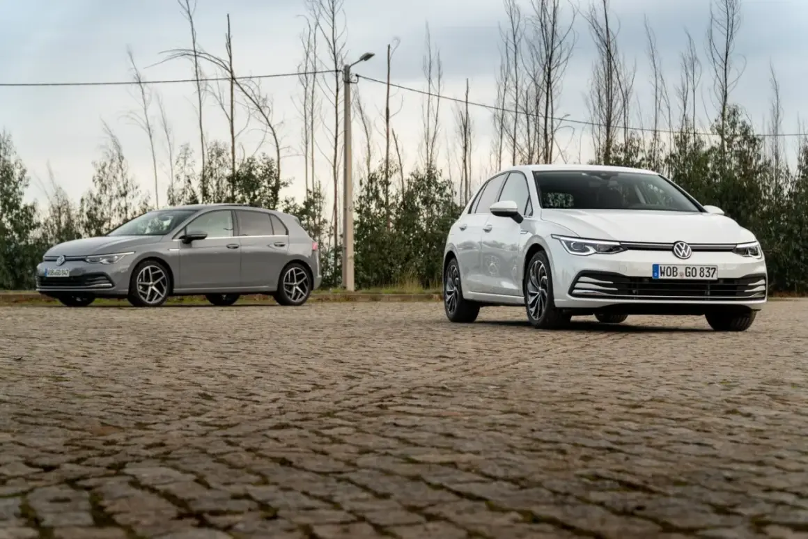 Deux Volkswagen Golf 8, une grise et une blanche, stationnées sur un sol pavé. La longueur de la Golf 8 est bien mise en valeur.