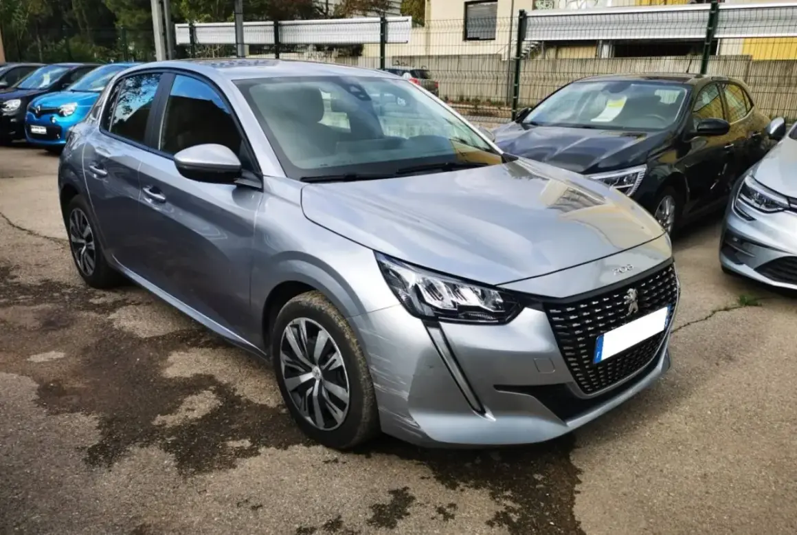 Peugeot 208 grise, prête pour sa révision. Le tarif de la révision Peugeot 208 est affiché sur le pare-brise.