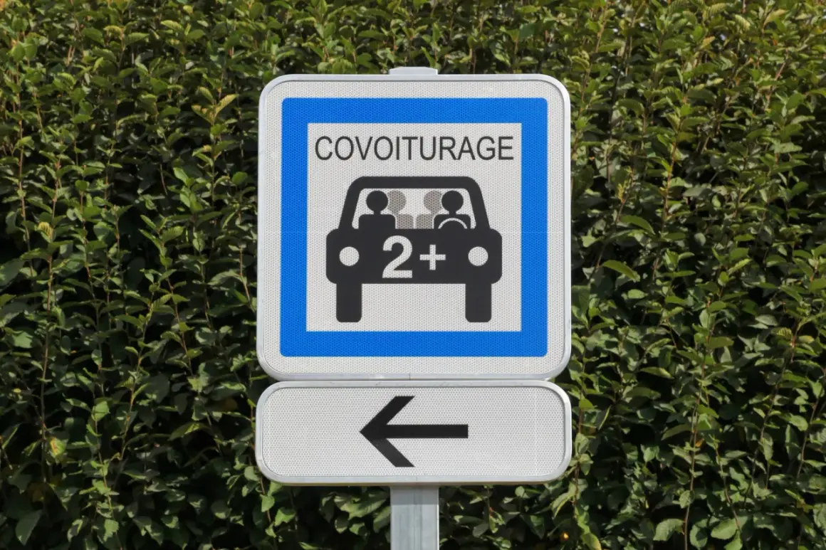 Panneau de signalisation "Covoiturage" indiquant une voie réservée aux véhicules de 2 personnes ou plus. Une flèche noire pointe vers la gauche.