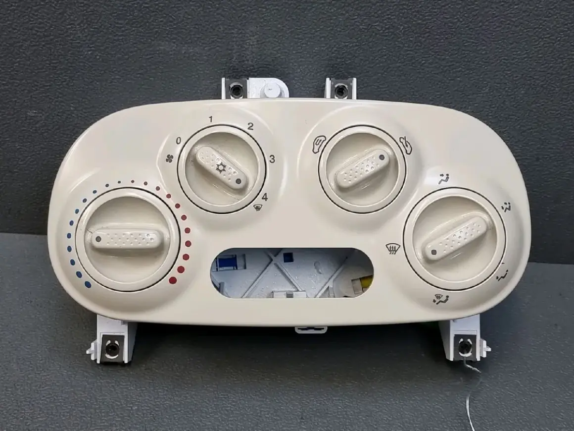 Commandes du clim fiat 500. Boutons pour régler la température et la ventilation, avec symboles de froid et de chaud.