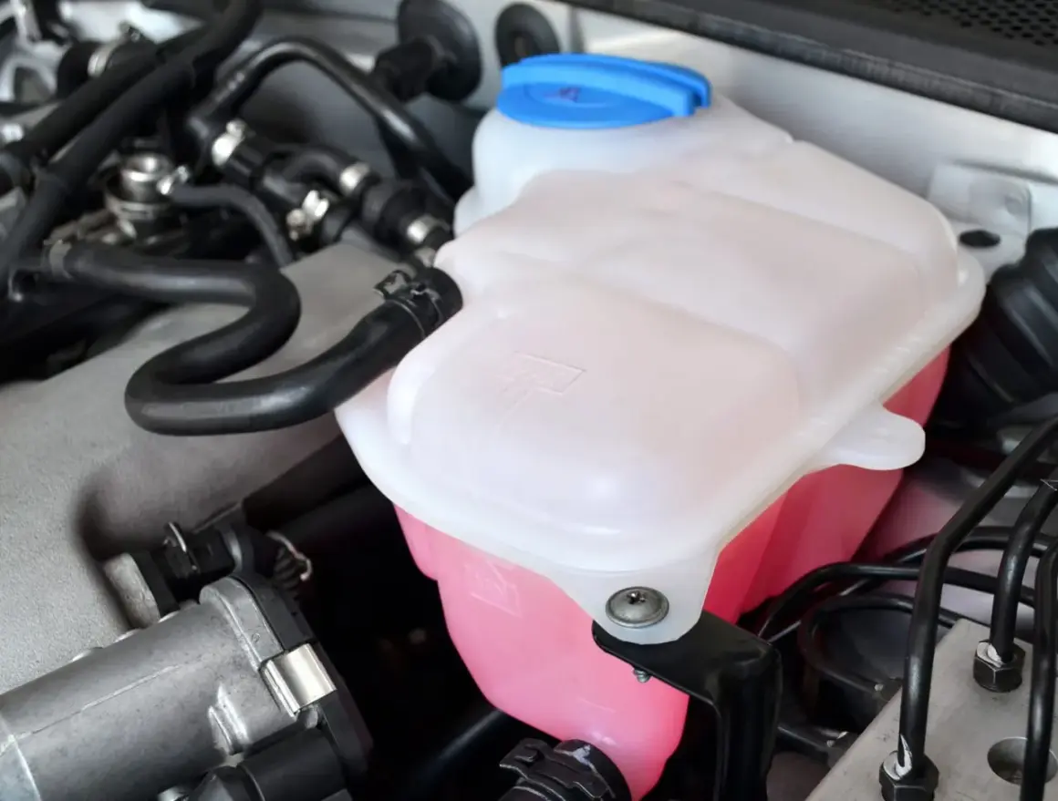 Réservoir de liquide de refroidissement rose vif, prêt pour le remplissage. Vérifiez le niveau avant de savoir ou mettre le liquide de refroidissement.