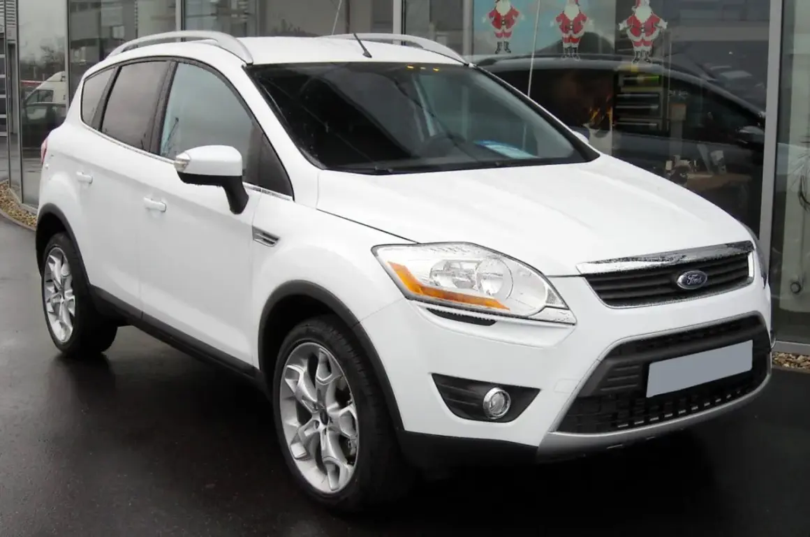 Un Ford Kuga blanc, symbole de fiabilité, garé devant un showroom.