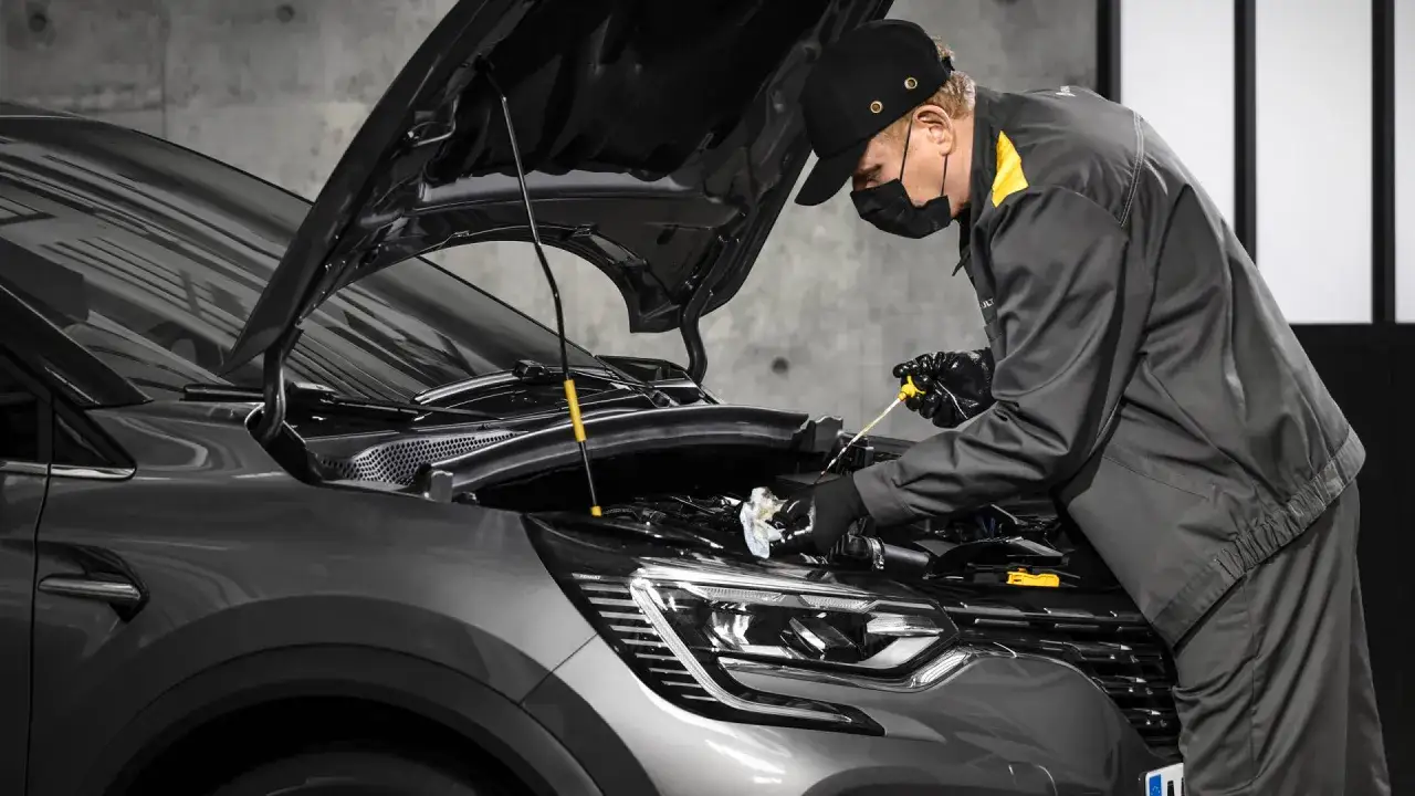 Un mécanicien vérifie le niveau d'huile d'une Renault. Obtenez le meilleur prix pour votre révision Renault.
