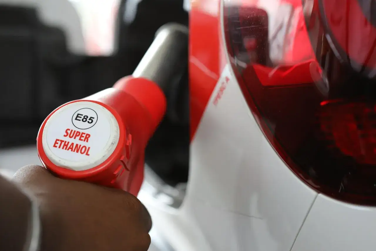 Main d'une personne tenant un pistolet de pompe &agrave; essence E85 Super Ethanol. Le prix d'installation d'un bo&icirc;tier &eacute;thanol chez Feu Vert est une bonne affaire.