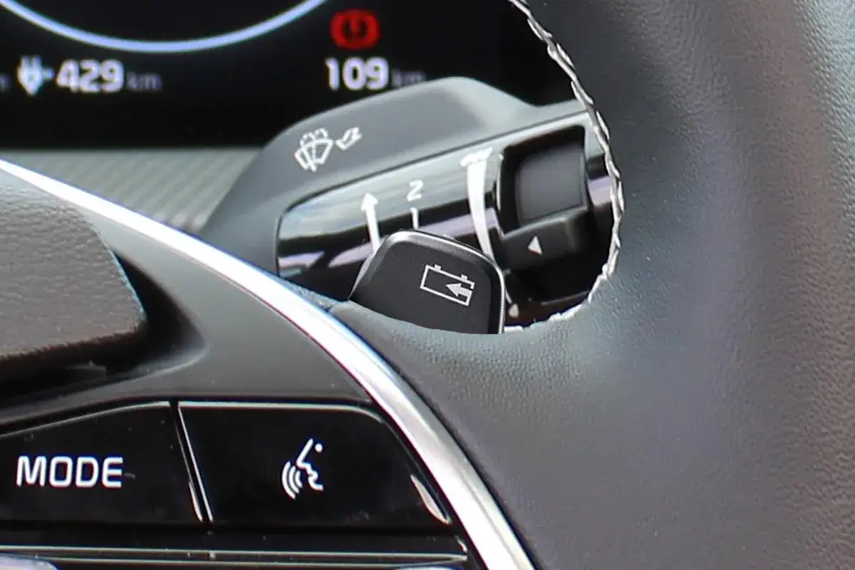 Bouton de batterie sur la palette au volant, prêt à gérer l'énergie du véhicule.