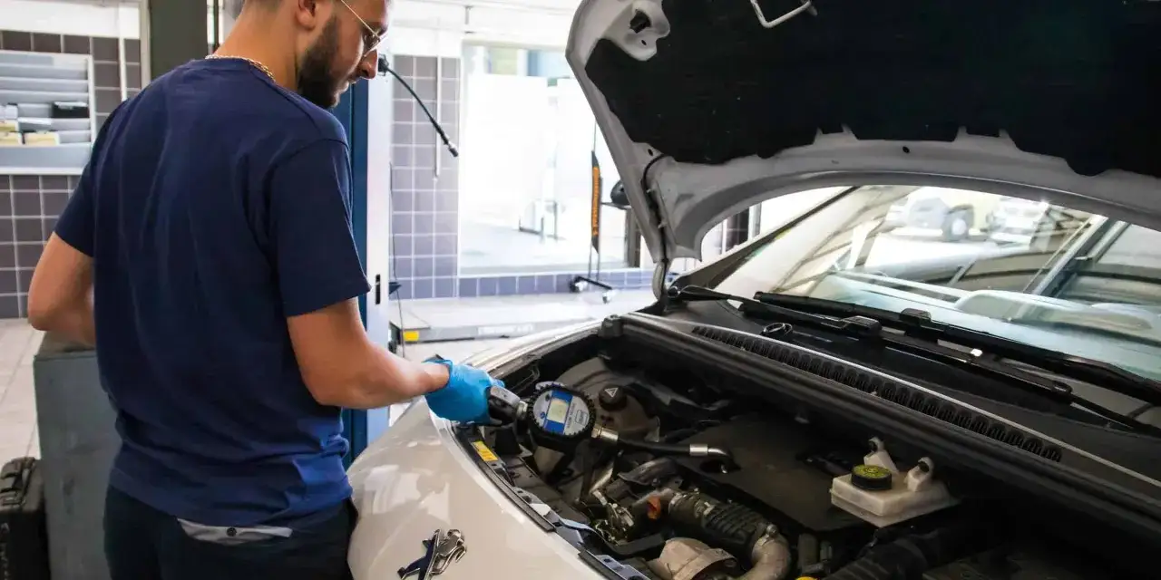 Mécanicien vérifiant le moteur d'une voiture. La fréquence de vidange d'une voiture qui roule peu est importante pour son bon fonctionnement.