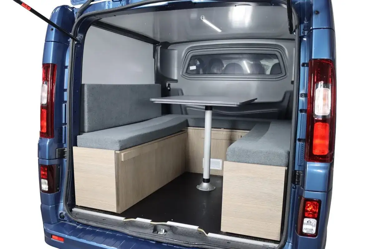 Aménagement intérieur d'un Ford Transit Custom aménagé en camping-car, avec banquettes, table et rangements. Avis Ford Transit Custom.
