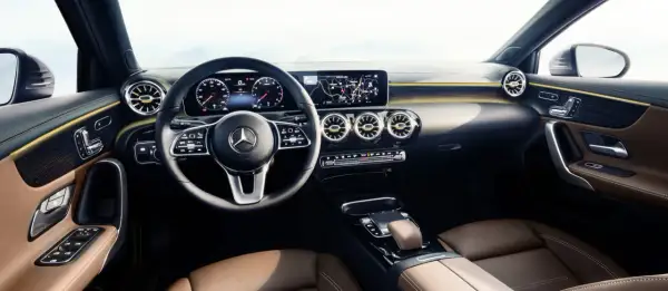 L'intérieur luxueux de la Mercedes Classe A, avec ses sièges en cuir brun, son volant moderne et son grand écran d'infodivertissement.