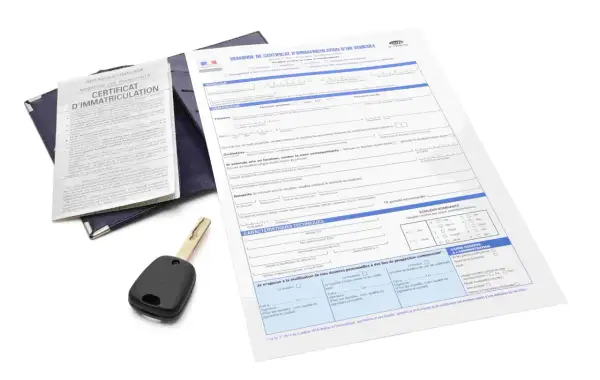 Document de demande de carte grise utilitaire, avec une clé de voiture posée dessus.
