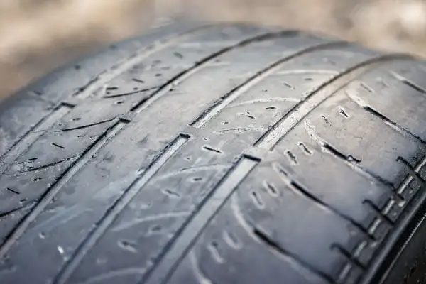 Gros plan sur un pneu usé, montrant les rainures aplaties. Difficile de dire combien de km avec des pneus dans cet état.