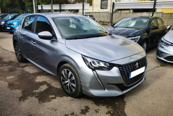 Peugeot 208 grise, prête pour sa révision. Le tarif de la révision Peugeot 208 est affiché sur le pare-brise.