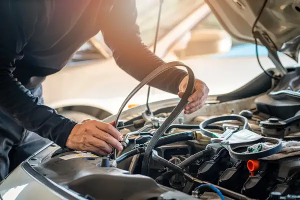 Mécanicien remplaçant la courroie de distribution d'une Twingo 2. L'entretien est essentiel pour le bon fonctionnement du moteur.